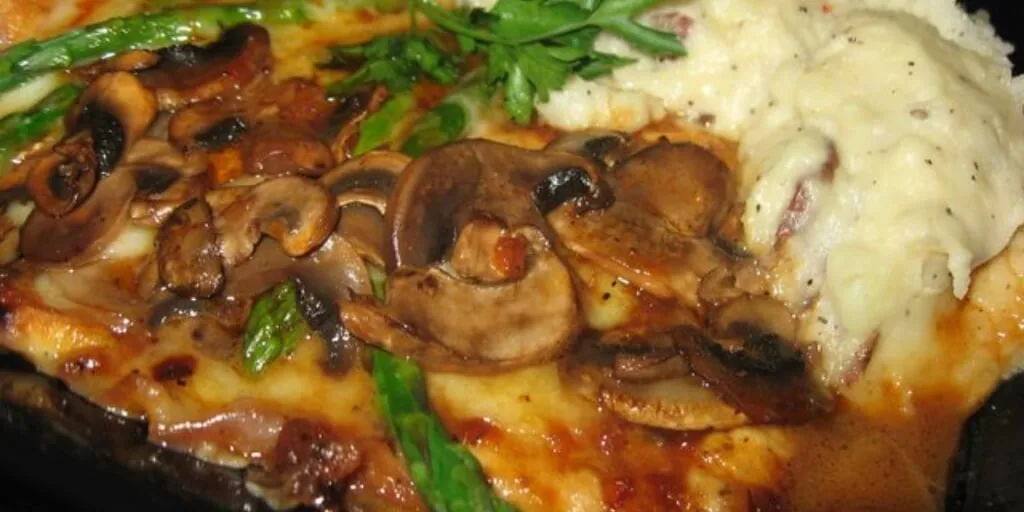 Frango Madeira pronto, com molho escuro e queijo derretido, acompanhado de purê de batata